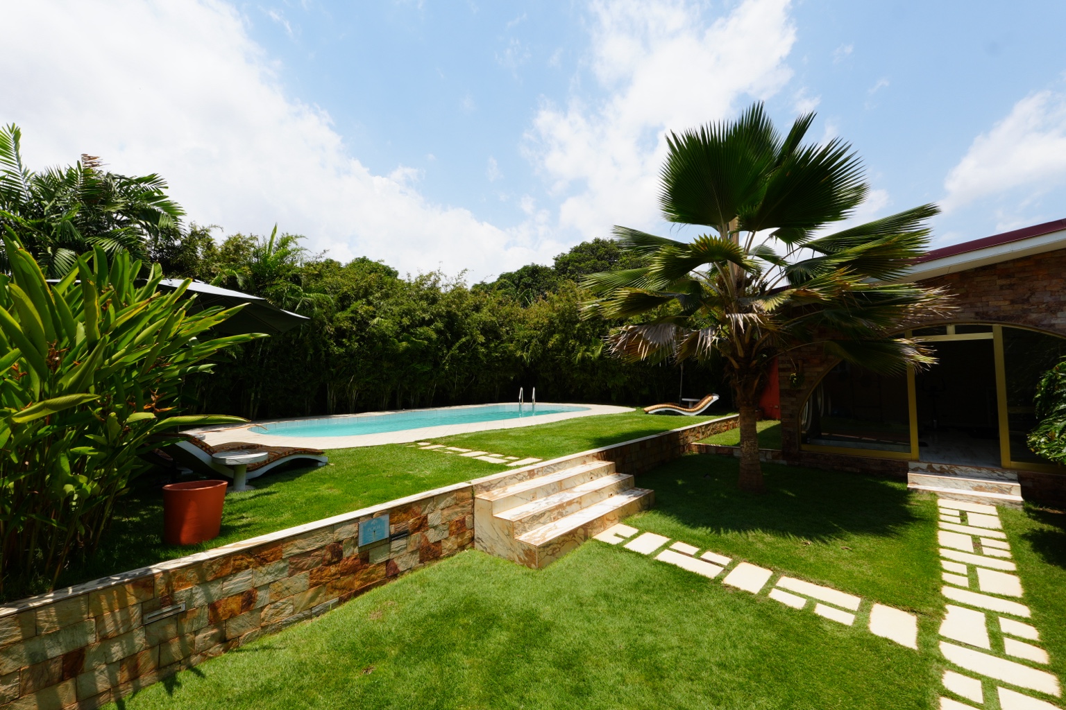 Pool and lawn terraces seen from the garden with stone steps