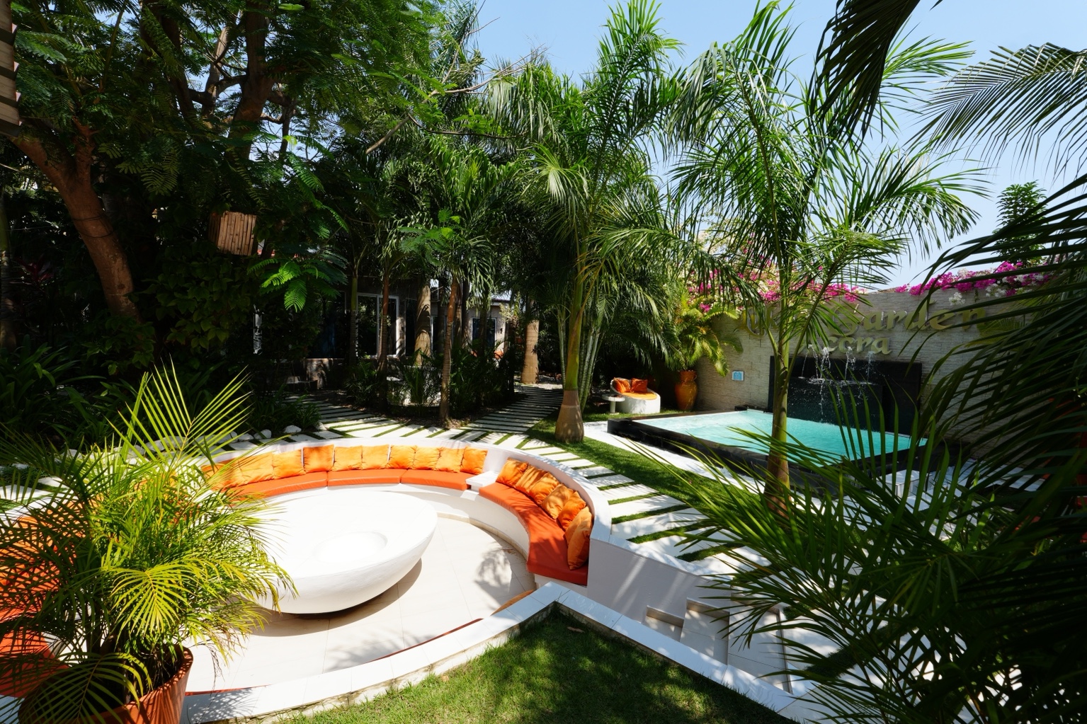 Circular sunken lounge with orange cushions beside the plunge pool