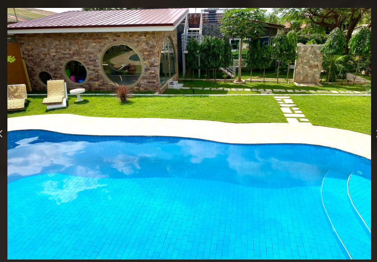 Daytime view of the large arched pool with brick facade and gardens